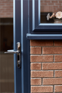 Close-up of uPVC backdoor handle with double glazing frame and brick wall