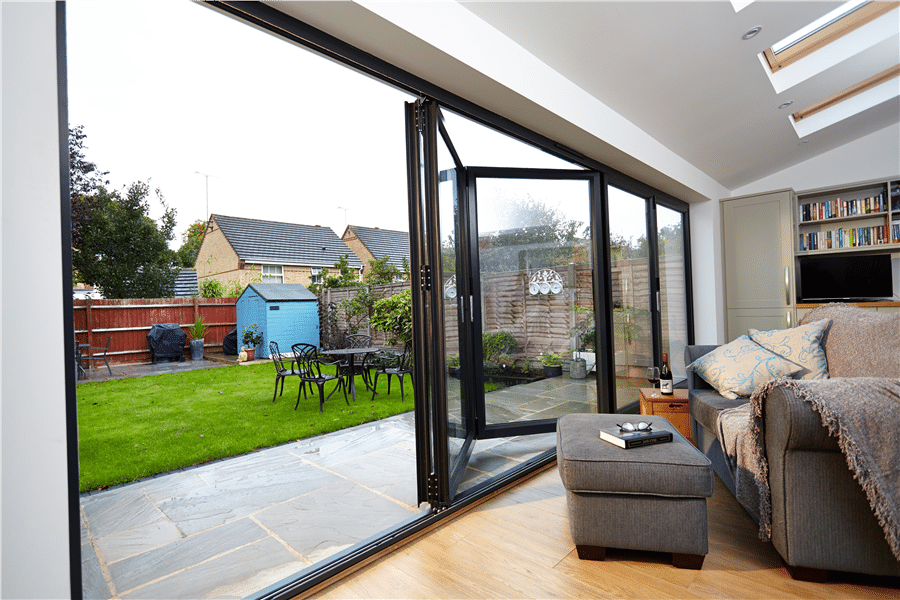 Large 5-panel aluminium bifold door fully open from living room to garden
