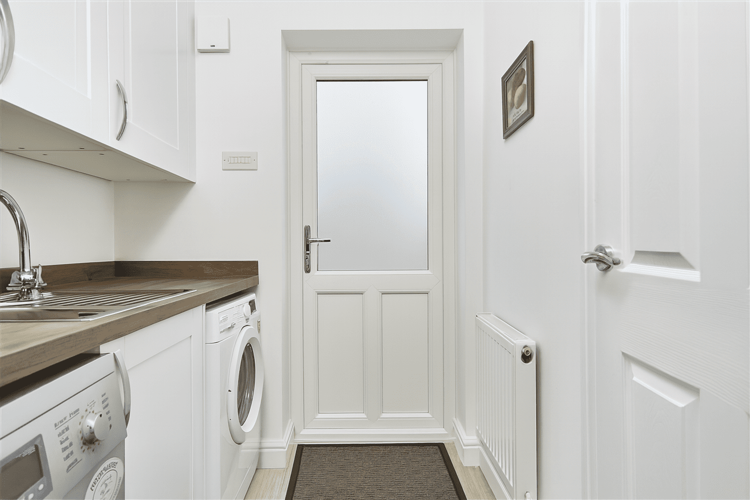 White uPVC back door with misted privacy glass in a utility room, beside sink and washing machine.