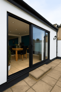 Modern black aluminium bifold doors with slim frames opening to a garden, low threshold.